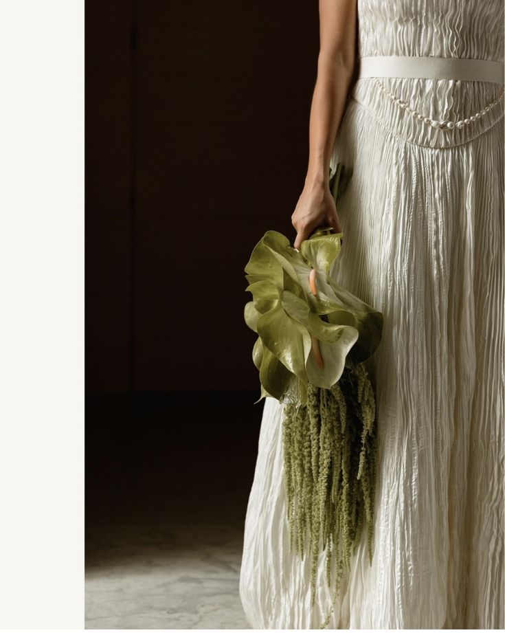 a woman in a white dress holding a bouquet