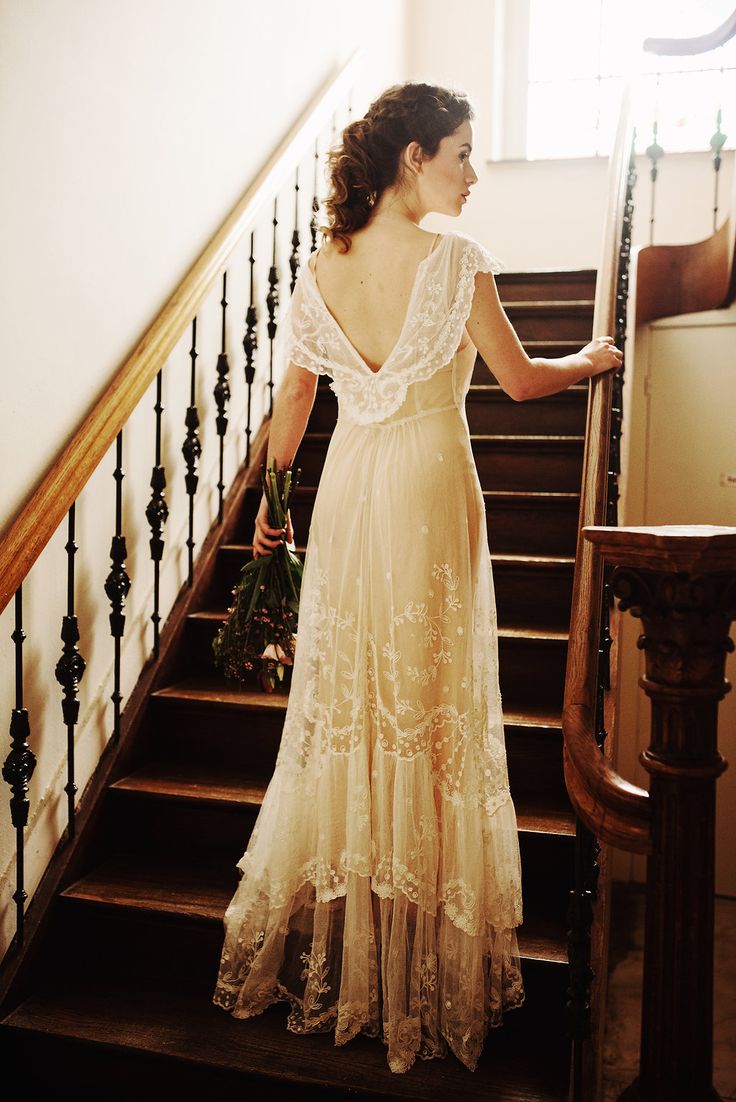 a woman in a dress is walking down the stairs