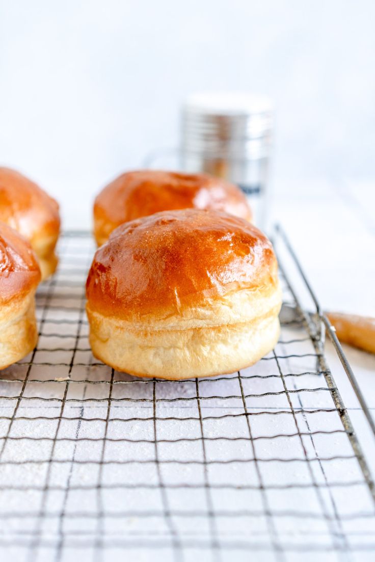 three doughnuts sitting on top of a cooling rack with the words super soft homemade burger buns