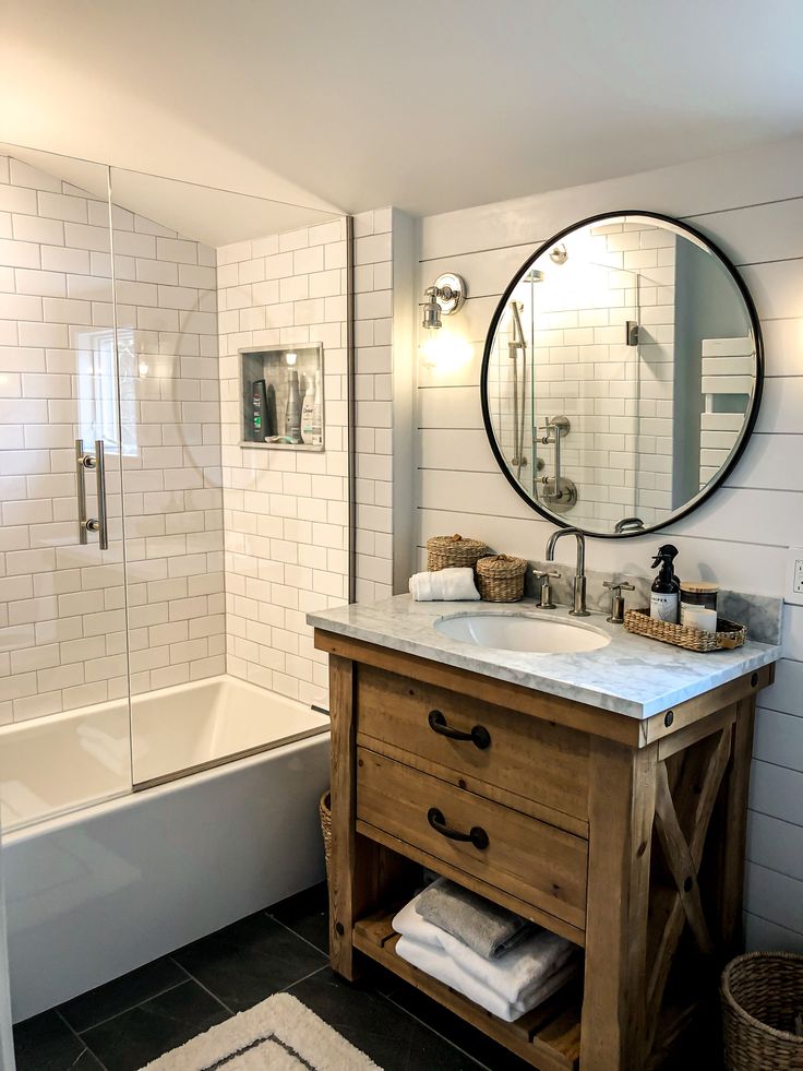 a bathroom with a sink, mirror and bathtub next to a rug on the floor