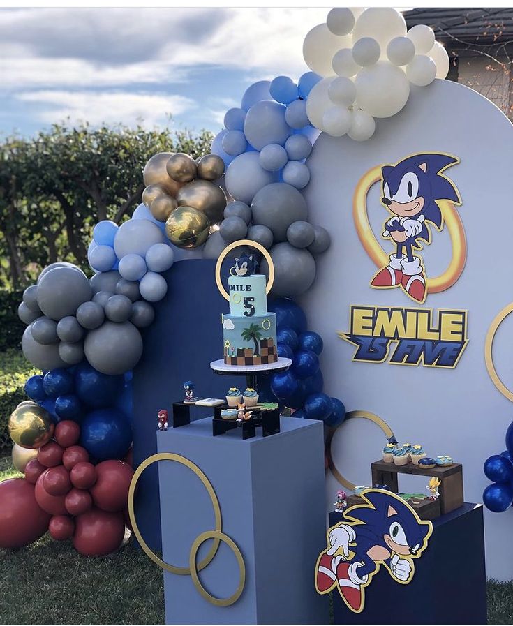 a sonic the hedgehog themed birthday party with balloons, cake and balloon archs