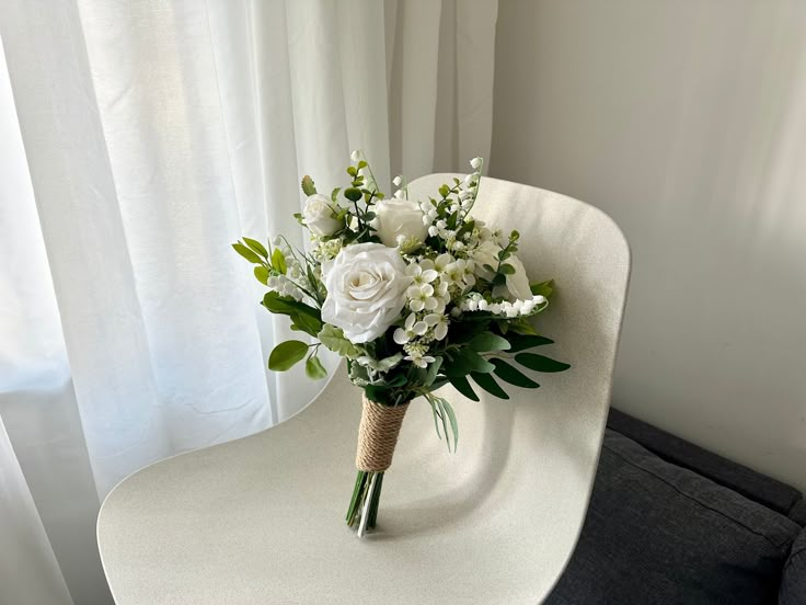 a bouquet of white flowers sitting on top of a chair