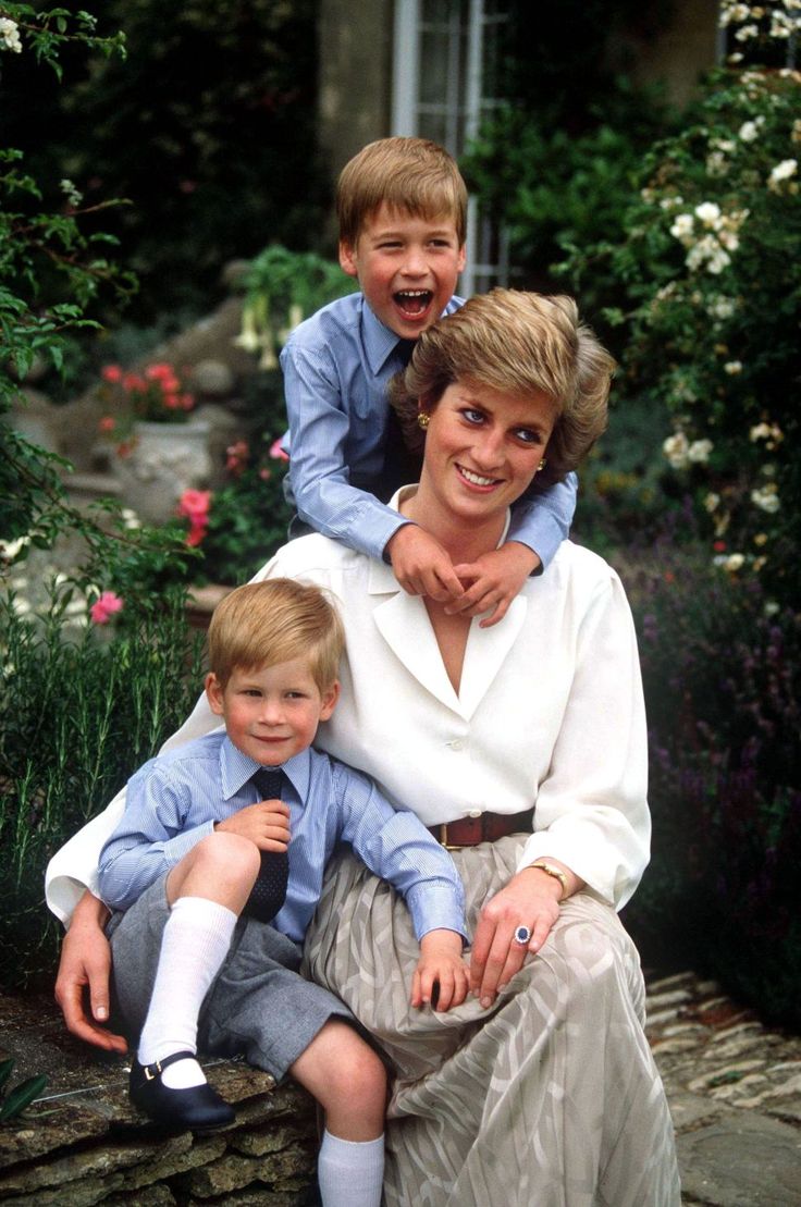 the young boy is sitting on the woman's lap as she smiles at the camera