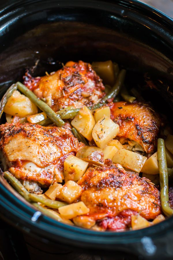 slow cooker full of chicken dinner with green beans and potatoes in the crock pot