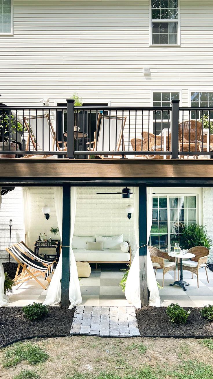 an outdoor living area with patio furniture and white curtains on the outside balcony railings