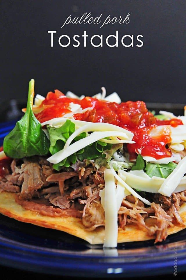 pulled pork tostadas with tomatoes, cheese and lettuce on a blue plate