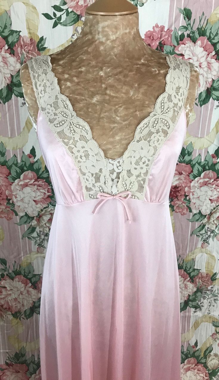 This is a Lovely Crepe Pink and Oat Beige Olga in style#9638 in size Large.  This gorgeous Pink nightgown has a darling Umpire waist style gown with lace on the bust as well as the straps in a light Oat color.  This beautiful nightgown has a U shaped back  that dips mid back.  This gown is sweet and romantic with its touch of lace and a sweet bow in the front bust.  This has to be one of my favorite nightgowns! I love the whimsical and romantic style of this gown.  It is incredibly stunning with V-neck Lace Trim Nightgown For Wedding, V-neck Lace Gown With Lace Trim, Feminine V-neck Nightgown With Lace Trim, Lace Sleepwear With Contrast Lace For Night, Feminine Dresses With Satin Trim, Feminine Lace Nightgown For Wedding Night, Coquette Lace V-neck Nightgown, Coquette Lace Nightgown For Bedtime, Coquette Lace Nightgown For Sleep