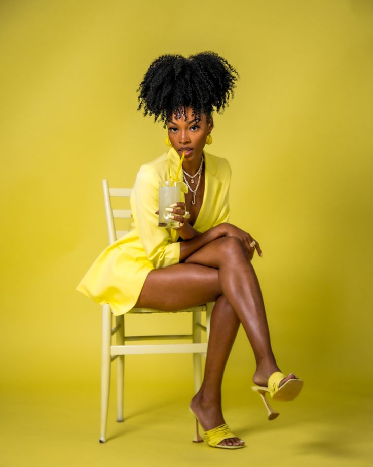 a woman sitting on a chair holding a cup