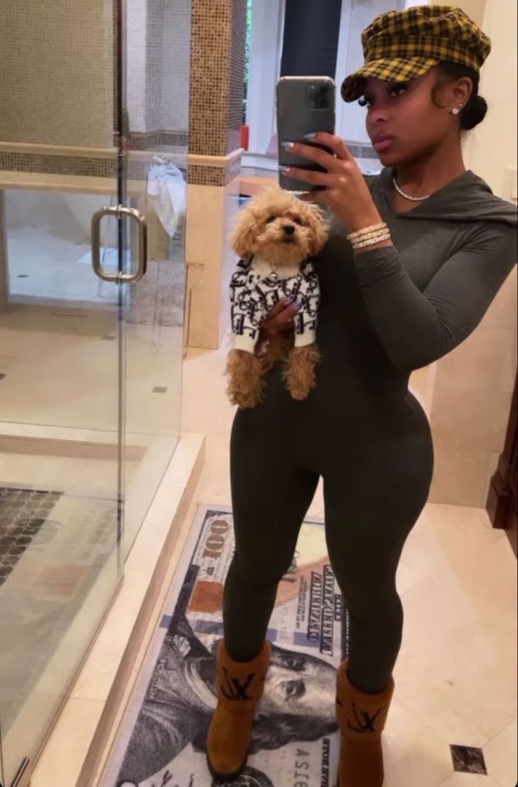 a woman taking a selfie in front of a bathroom mirror holding a teddy bear