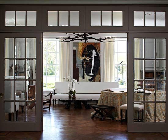 a living room with french doors leading to the dining room and sitting area in it