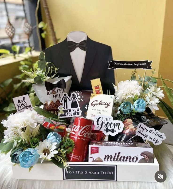 a man's tuxedo gift box with flowers, chocolates and candy