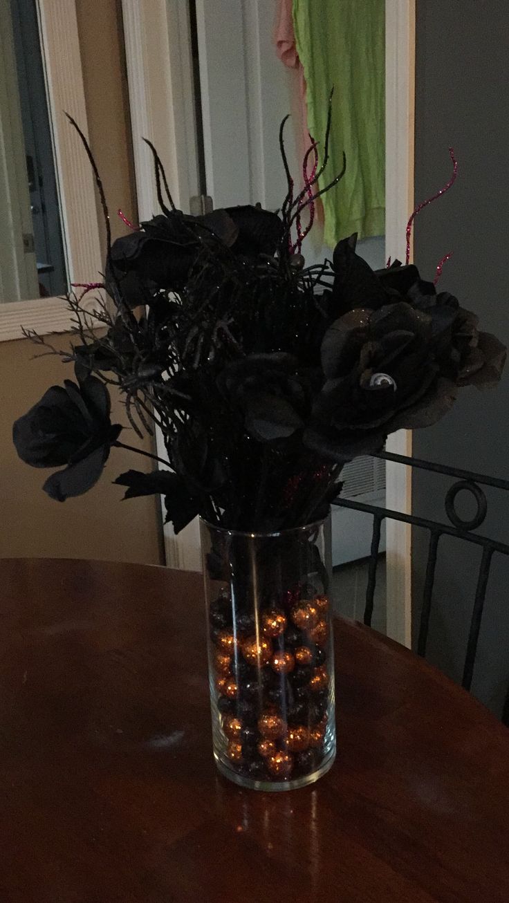 a vase filled with flowers on top of a wooden table