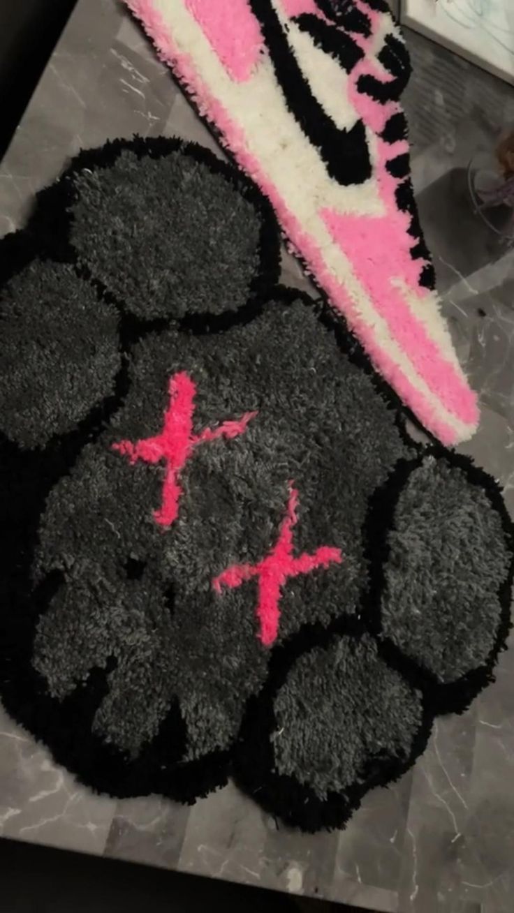 a pair of pink and black sneakers on top of a rug next to each other