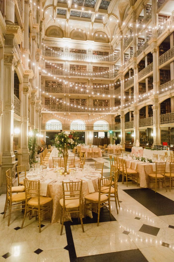 the inside of a large building with tables and chairs set up for an elegant dinner