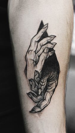 a tattoo on the arm of a person holding something in their hand with both hands