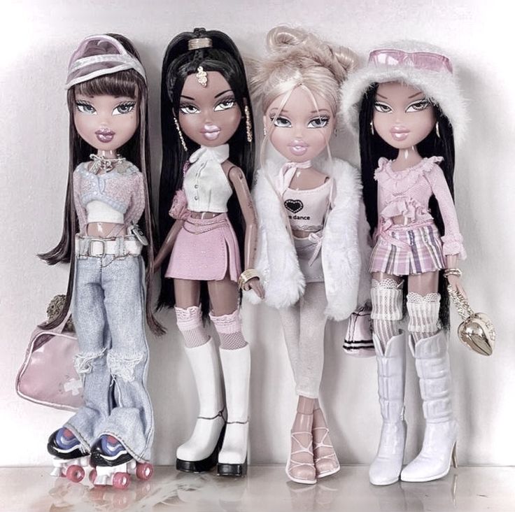 three dolls standing next to each other in front of a white wall with fur on it