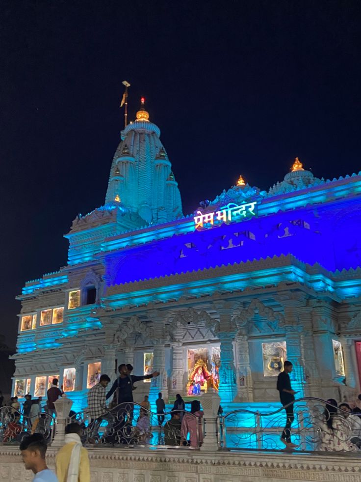 people are standing in front of a building lit up with blue lights