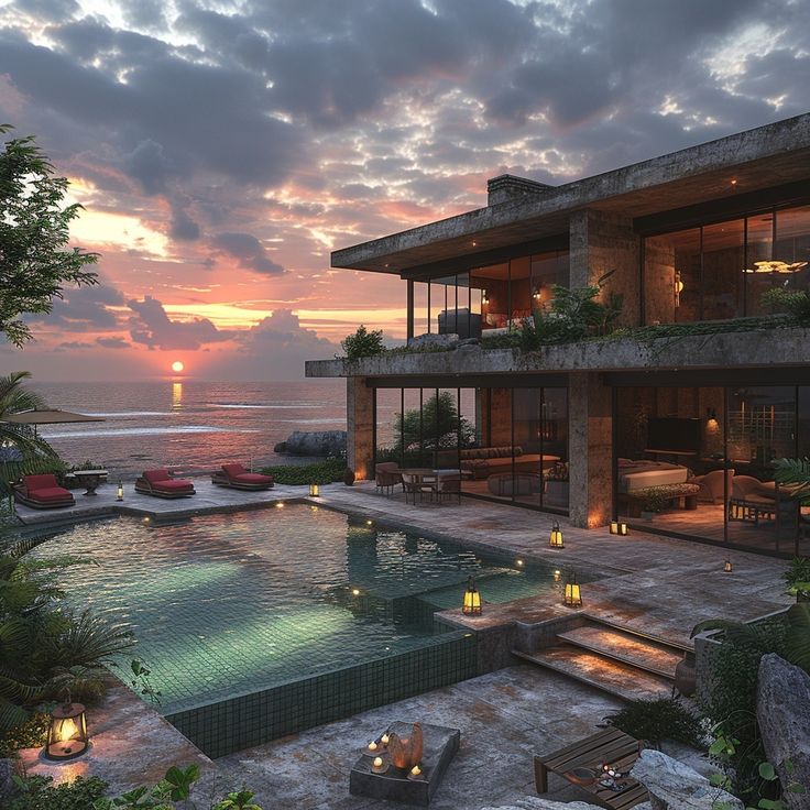 a large house with a pool in front of it at sunset or sunrise, overlooking the ocean