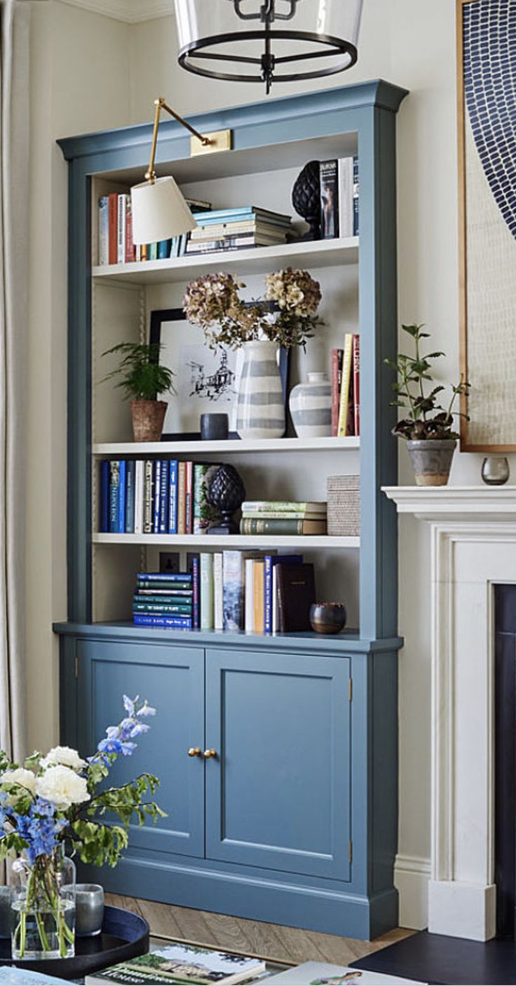 a living room with a blue bookcase and fireplace