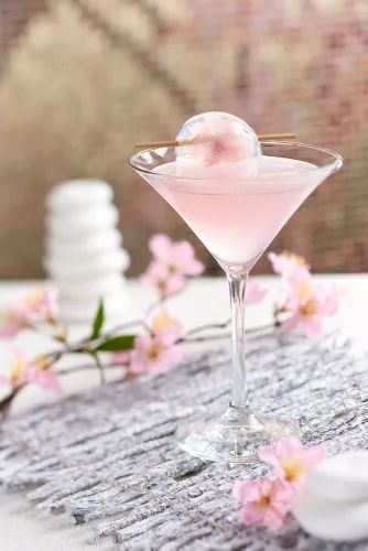 a pink drink in a martini glass on a table