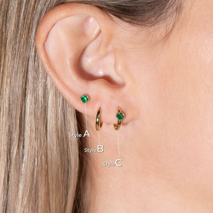 Overview: This earring set features a contemporary mix of styles: Huggie hoop and stud earrings, crafted from 14k gold. The hoop and stud earrings boast lab-created emerald gemstones, making them a perfect choice for those born in May (emerald birthstone). The versatile design allows for wear in multiple piercings including lobe, conch, cartilage, helix, and tragus, making this set ideal for everyday accessorizing or creating a trendy, curated ear look. This captivating earring set features the Minimalist Everyday Huggie Earrings With Birthstone, Minimalist Huggie Birthstone Earrings, Modern Small Hoop Piercings As A Gift, Minimalist Birthstone Huggie Earrings, Modern Huggie Piercings As Gift, Modern Huggie Piercings For Gift, May Birthstone Round Hoop Earrings For Pierced Ears, Minimalist Hoop Earrings With Birthstone, Minimalist Gold Hoop Earrings With Birthstone