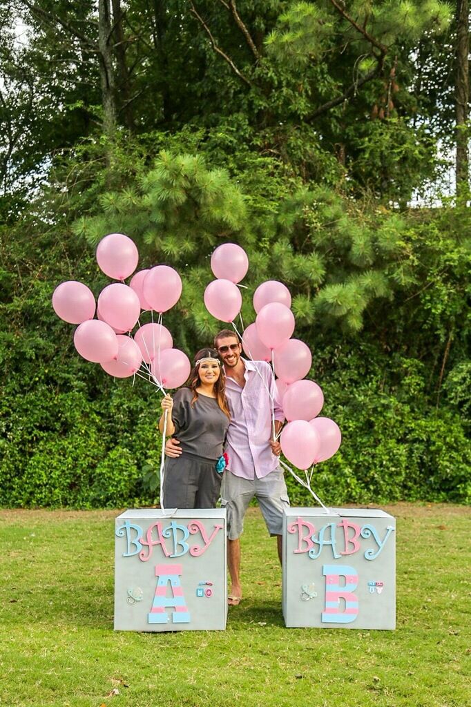 a man and woman standing in front of two blocks with balloons attached to them that say happy birthday ale