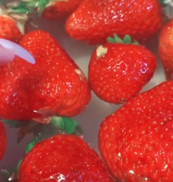 the strawberries are being washed and placed in a bowl to be used as an appetizer