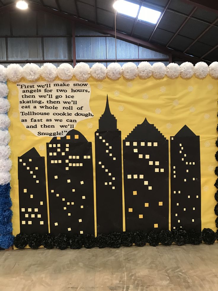 a bulletin board is decorated with black and yellow cityscapes, pom poms, and white balls