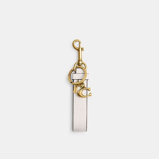 a gold and white keychain hanging from a hook