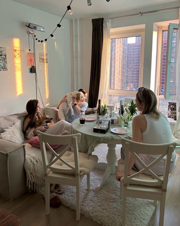 three women sitting at a table in a living room