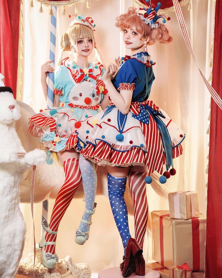 two women dressed as clowns are posing for a photo with a cat and teddy bear