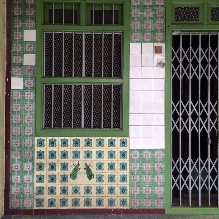 a green and white building with two windows