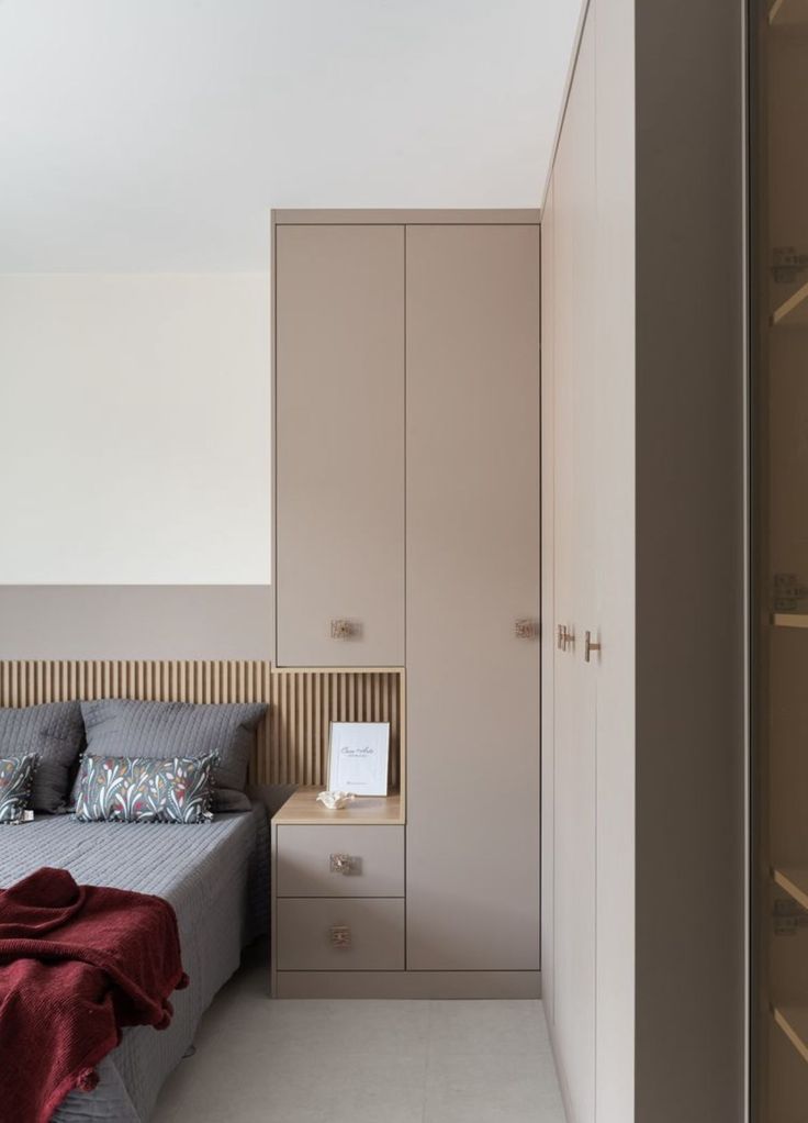 a bed sitting next to a closet in a bedroom