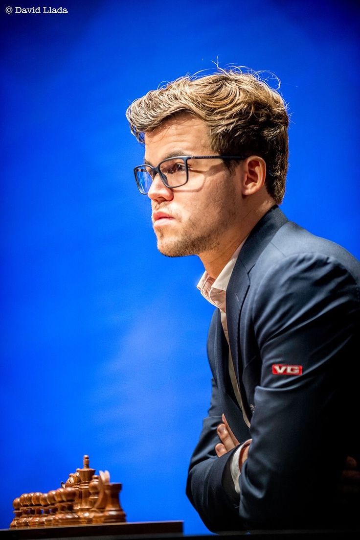 a man sitting at a table with a chess board in front of him and looking off into the distance