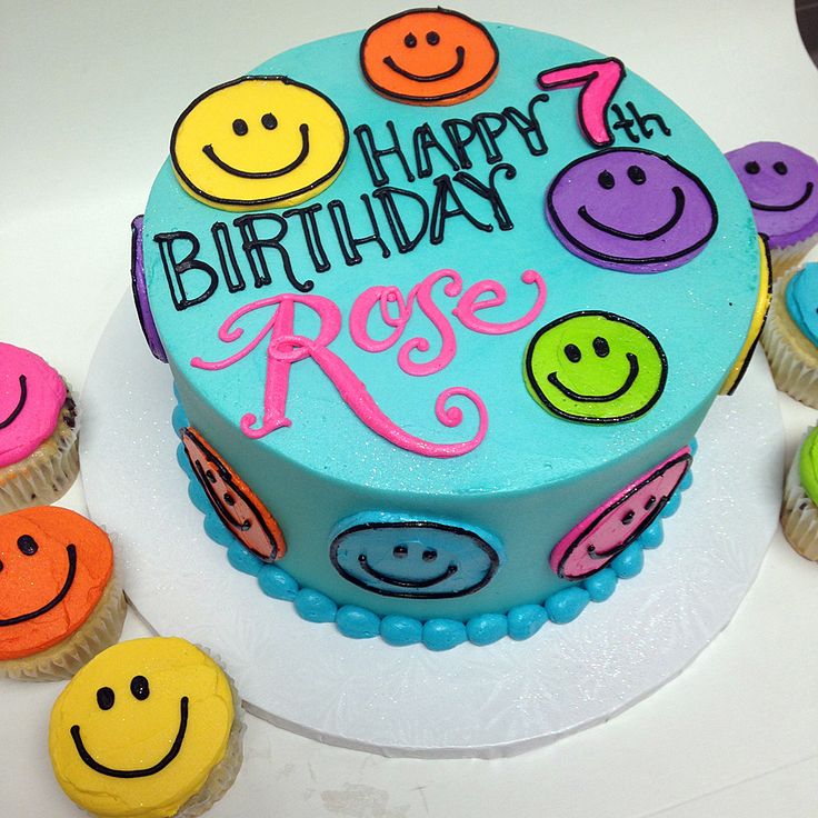 a birthday cake decorated with colorful smiley faces