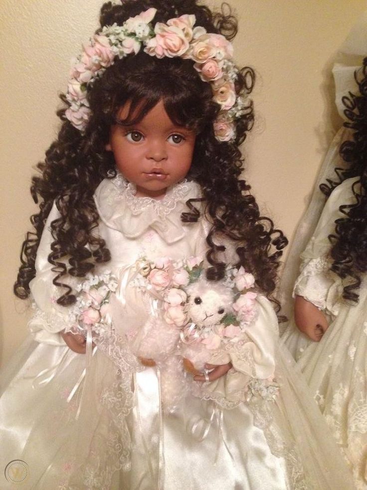 two dolls dressed in wedding gowns and flowers