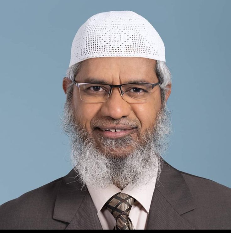 a man in a suit and tie wearing a white hat