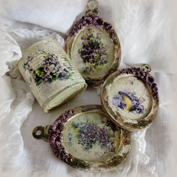 four pieces of porcelain sitting on top of a white cloth