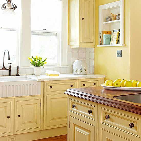 a kitchen with yellow walls and wooden floors