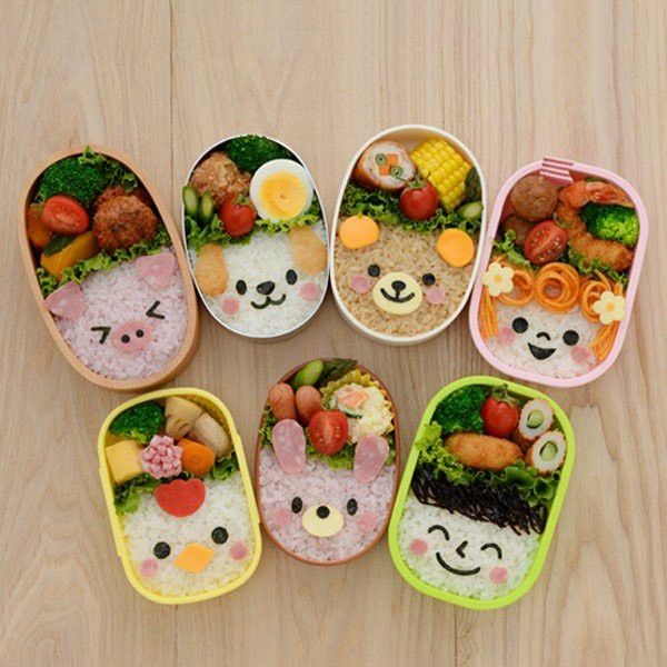 five bento boxes with food in them on a wooden surface, including rice and vegetables