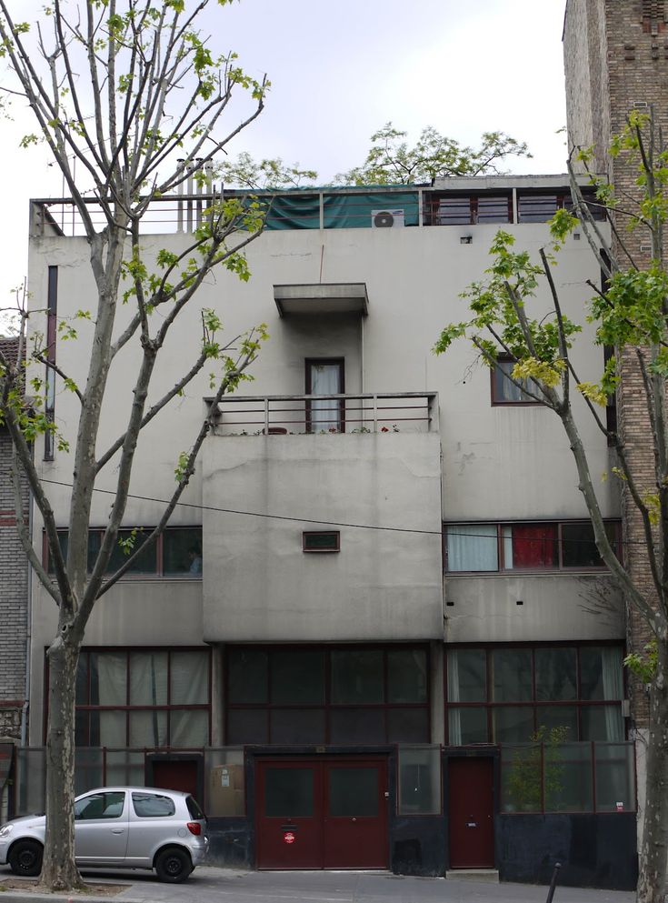 an apartment building with cars parked on the street