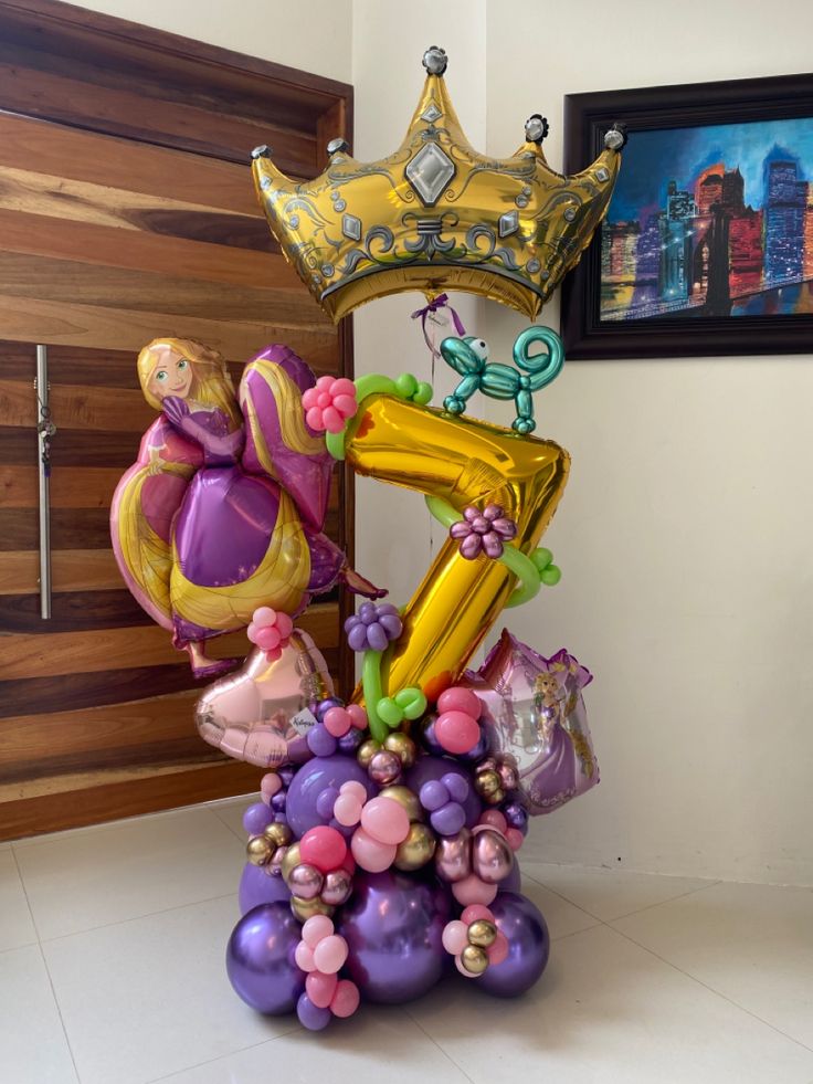 a balloon sculpture with the letter e on it and balloons in the shape of princesses