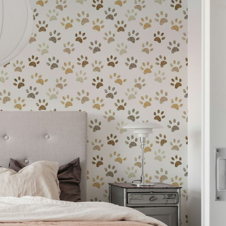 a dog paw wallpaper in a bedroom next to a night stand and nightstand with a lamp on it