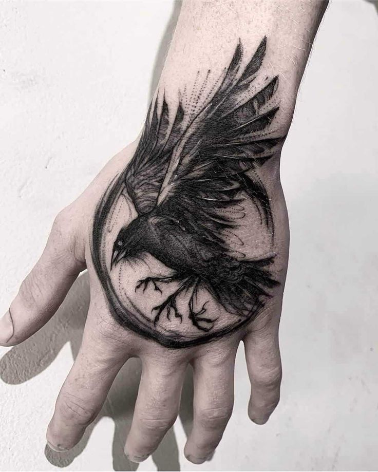 a hand with a black bird on it and a clock in the middle is shown