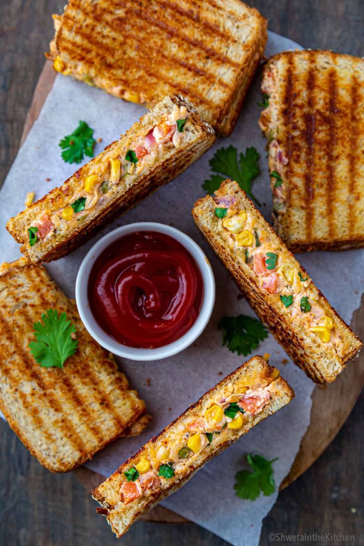 grilled cheese sandwiches with ketchup and garnish on a paper towel