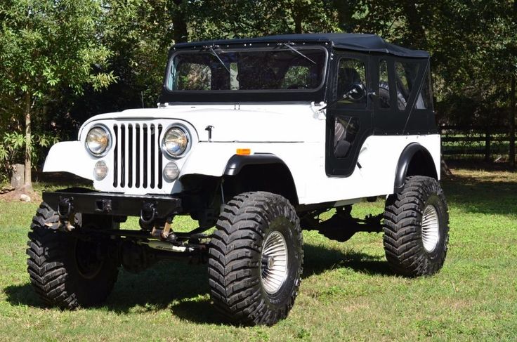 an old jeep is parked in the grass