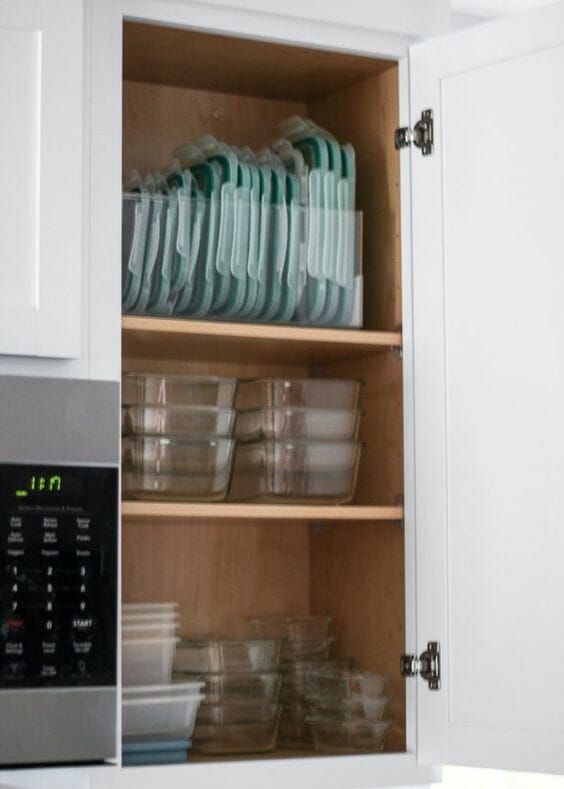 an open cabinet filled with dishes and cups