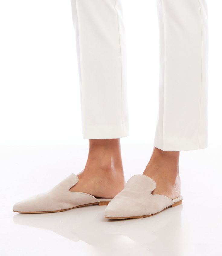 From daytime strolls to evening soirees, these handcrafted mules seamlessly transition from one event to the next. The suede material not only exudes a luxurious aesthetic but also conforms to your foot, providing a personalized and comfortable fit. 100% Leather Imported Flat Sole Runs small; we recommend sizing up Avoid water - rub with dry cloth | Karen Kane Suede Leather Mules in Cream, Size 37, Plain Formal Suede Slip-ons With Almond Toe, Fall Evening Slip-on Mules, Elegant Slip-on Slippers With Leather Sole, Elegant Slip-on Slippers With Round Toe, Chic Beige Almond Toe Slip-ons, Elegant Beige Flat Heel Mules, Elegant Almond Toe Slip-ons For Fall, Elegant Leather Slippers With Leather Sole, Elegant Slip-ons For Spring Galas