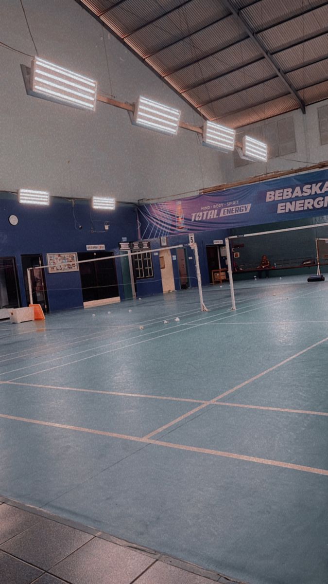 an indoor tennis court with blue and white tiles