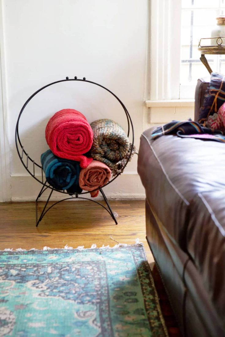 a bed with blankets on top of it next to a window and rug in the corner